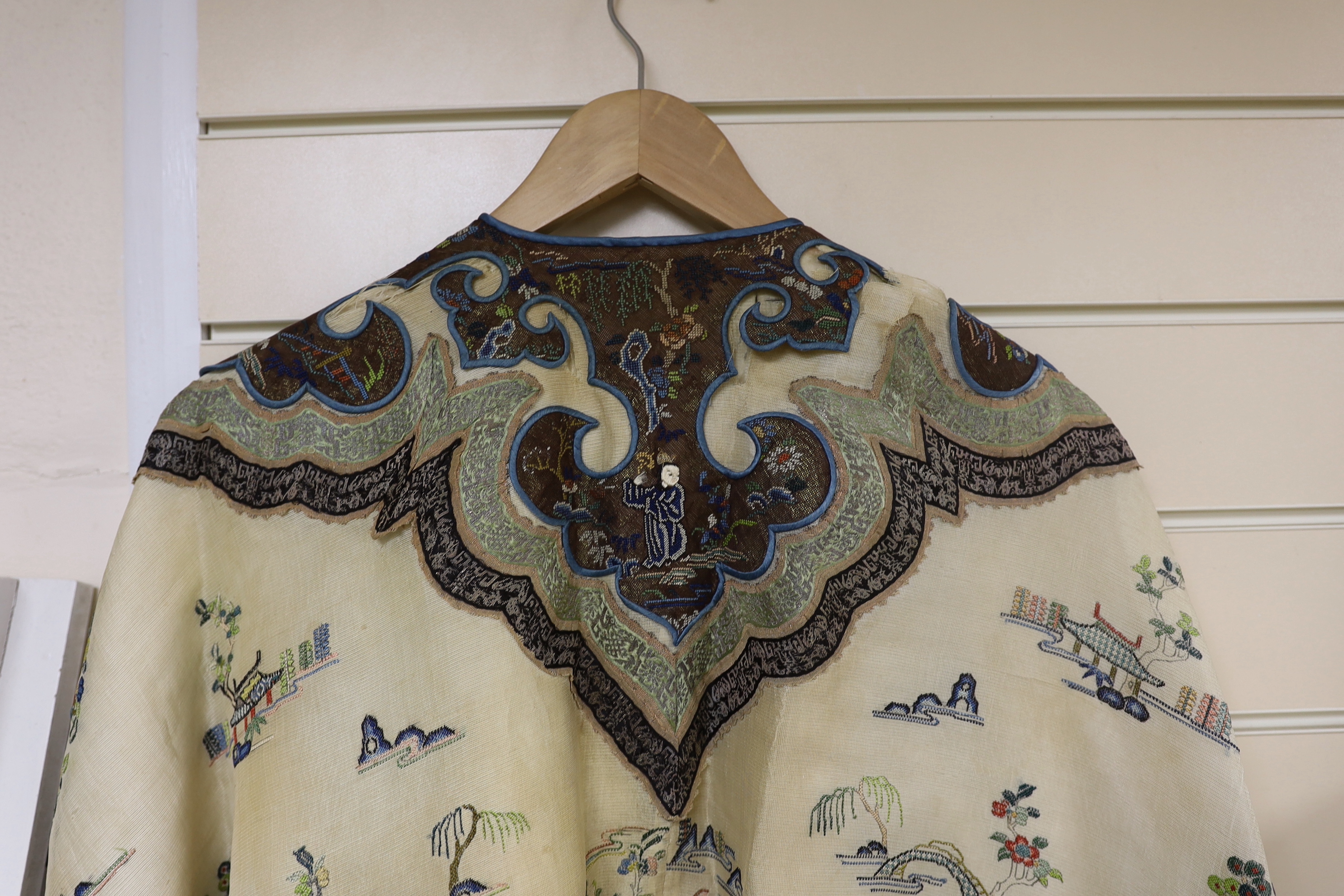 A late 19th/early 20th century Chinese gauze summer robe embroidered with flowers, figures and pagodas, 85cm high